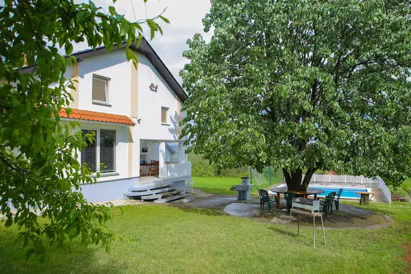 Dvorište vile sa stolom za druženje pod drvetom