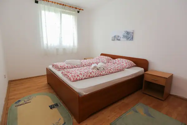 Spavaća soba sa drvenim bračnim krevetom
