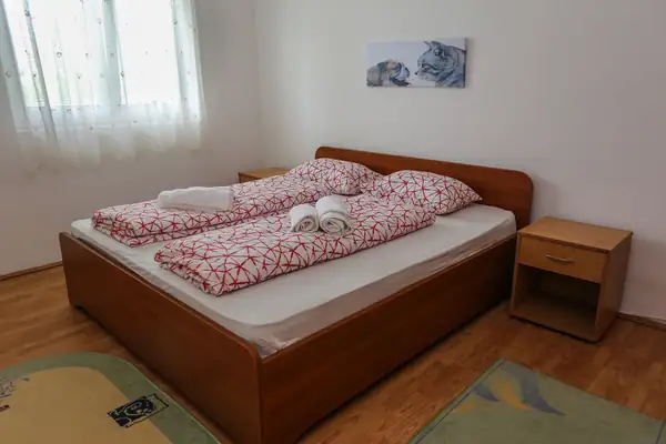 Bračni krevet sa crveno-belom posteljinom