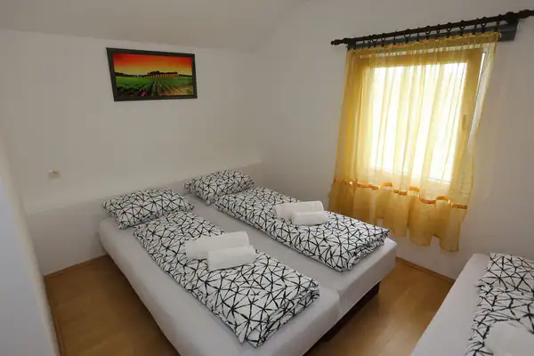 Kreveti sa crno-belom posteljinom pored prozora