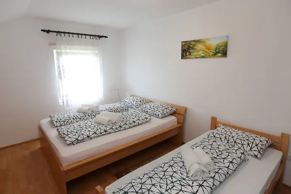 Soba sa dva kreveta i slikom na zidu