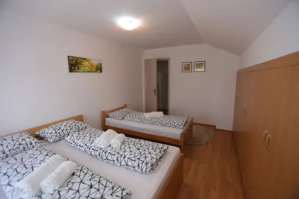 Soba za goste sa više kreveta i peškirima