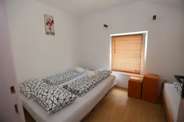 Soba sa krevetima i roletnom na prozoru