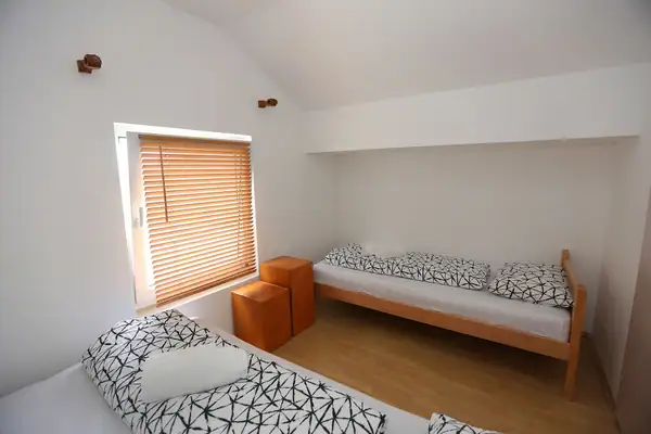 Soba sa krevetima i drvenim stočićima