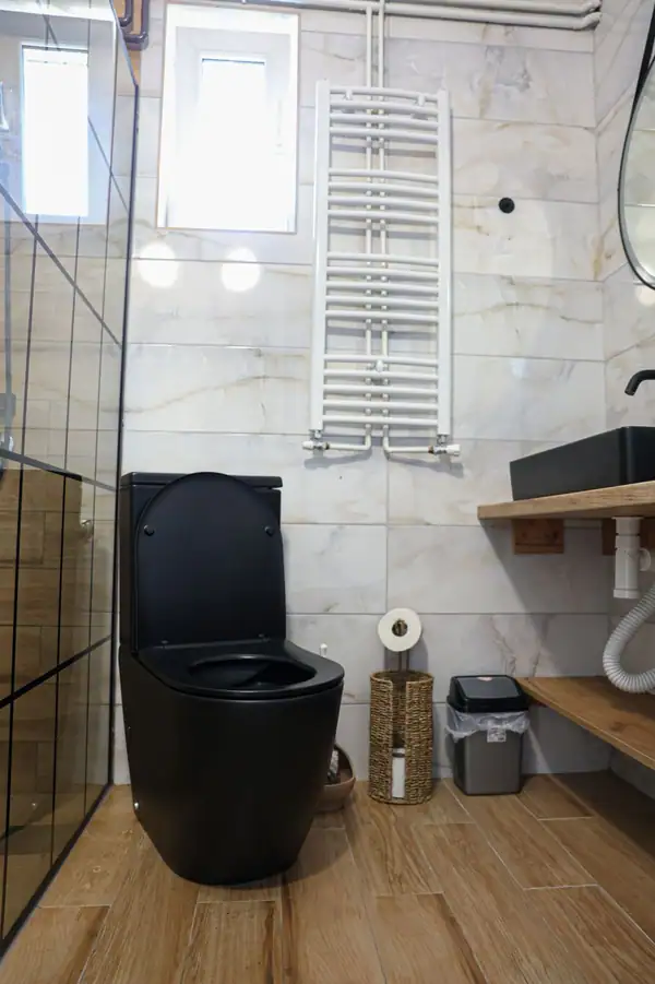 Moderno kupatilo sa crnom WC šoljom i tušem